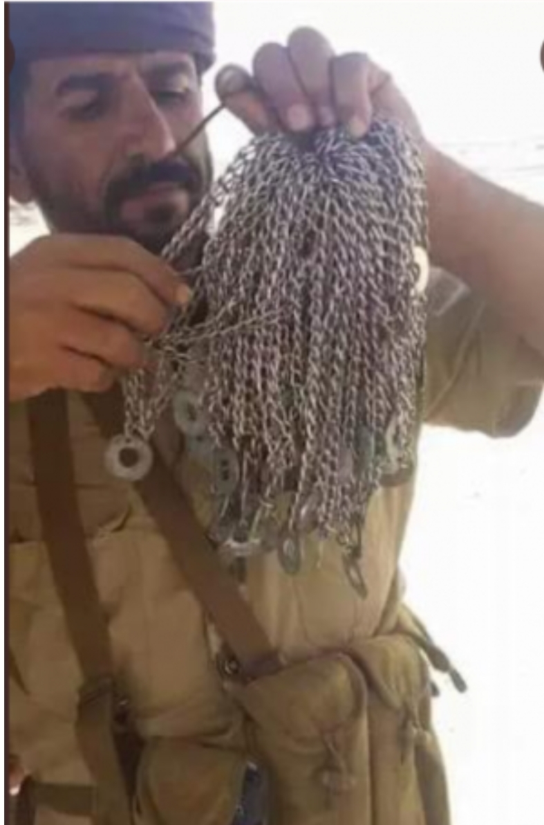 شاهد صوره لعدد غير متوقع من السلاسل الحوثيه بيد جندي بالجيش الوطني وهو يحصي عدد قتلاهم  